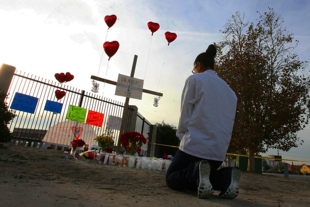 Melissa Smith of the Inland Emprire kneels in prayer at the make-shift memorial for the San Bernardino shooting victims at the corner of Waterman Ave. and Orange Show Rd. on Friday, Dec. 4, 2015. (File photo by Kurt Miller, The Press-Enterprise/SCNG)