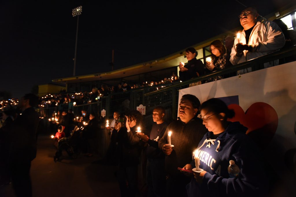 From right Raylien Young and Joseph Flores, bottom both students at San Bernardino Valley College and more than 2,000 others show their support during candle light vigil for the victims of yesterdays mass shooting at the Inland Regional Center is head at San Bernardino's San Manuel Stadium in San Bernardino Thursday, Dec. 3, 2015. - The Press-Enterprise