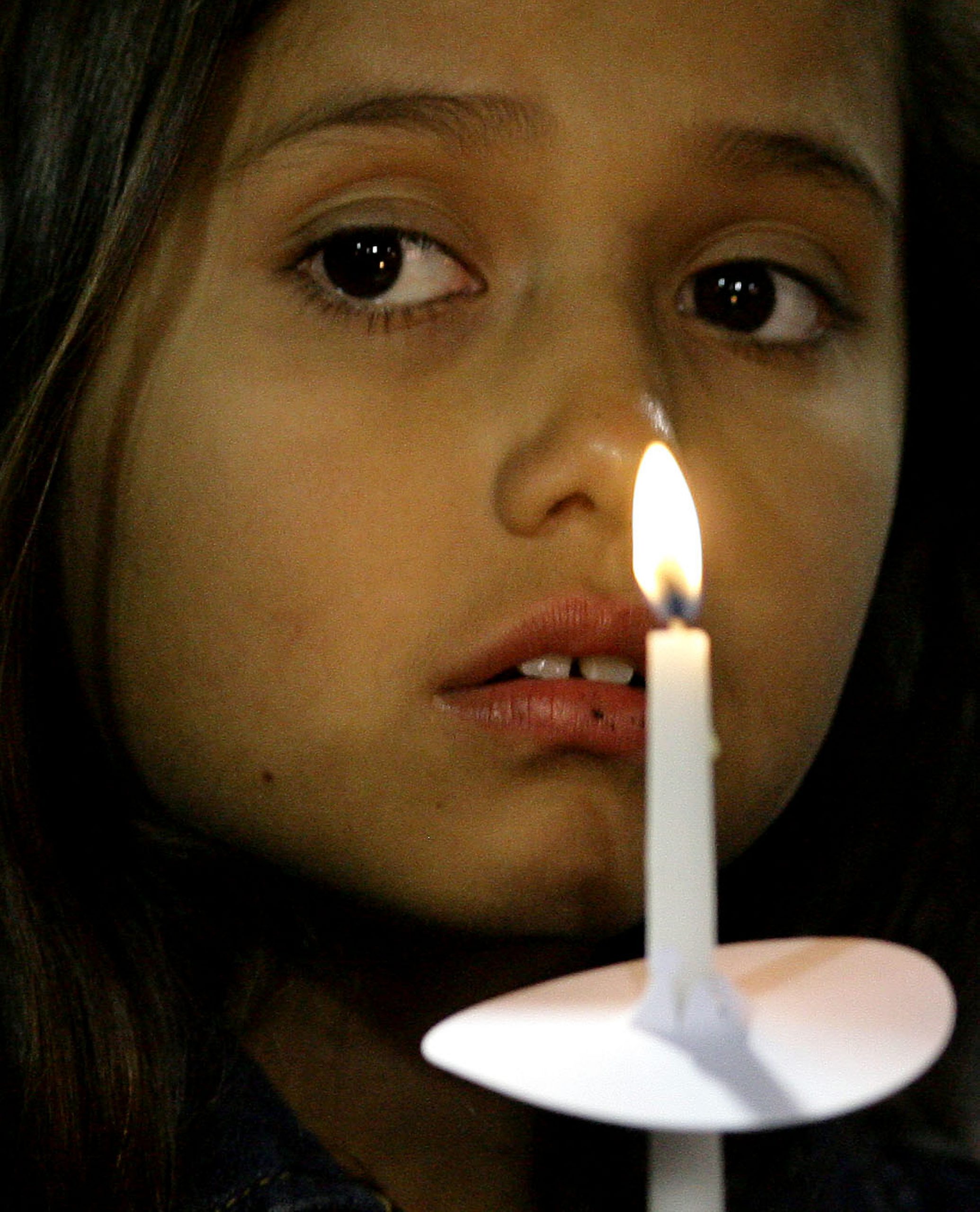 A little girl holds a candle during the candle light vigil for the victims of yesterdays mass shooting at the Inland Regional Center is head at San Bernardino's San Manuel Stadium in San Bernardino Thursday, Dec. 3, 2015. - The Press-Enterprise