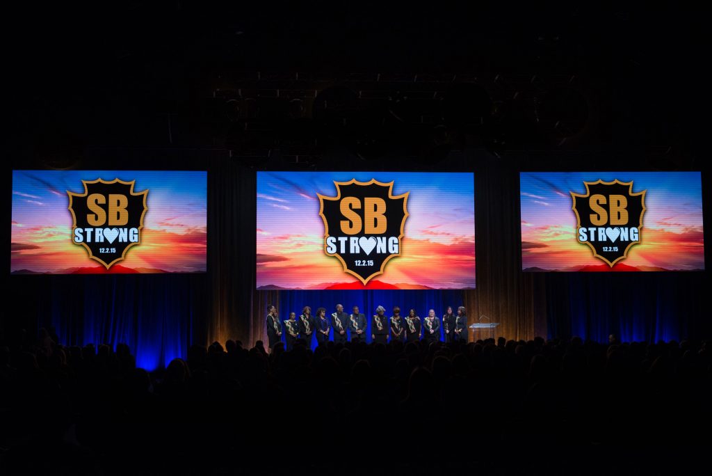 SB Strong screens are displayed above members of a choir during the County Family Gathering at Toyota Arena