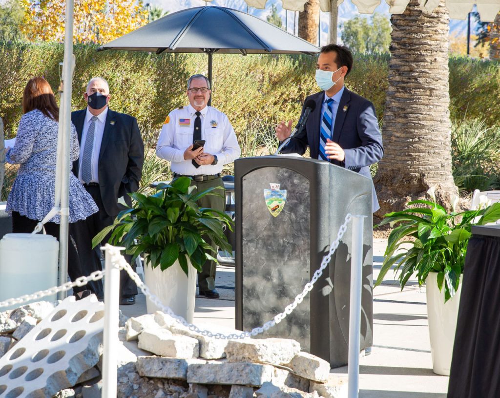 CEO Leonard Hernandez stands at a podium addressing the audience at the Curtain of Courage Memorial Concept Unveiling