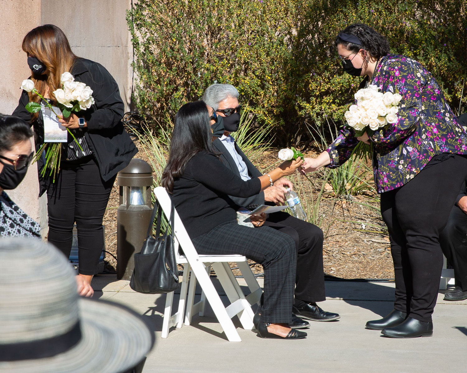 A woman passes out flowers to family members of December 2, 2015 victims