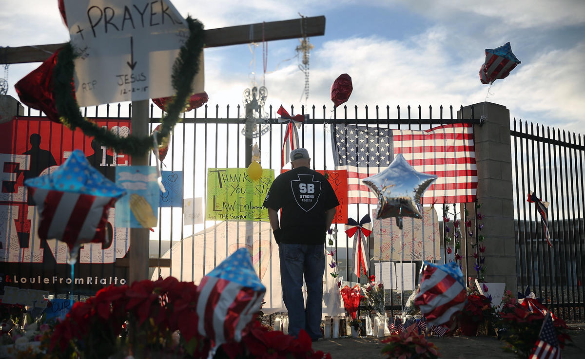 A man stands outside the makeshift memorial near the site of the December 2, 2015 attack