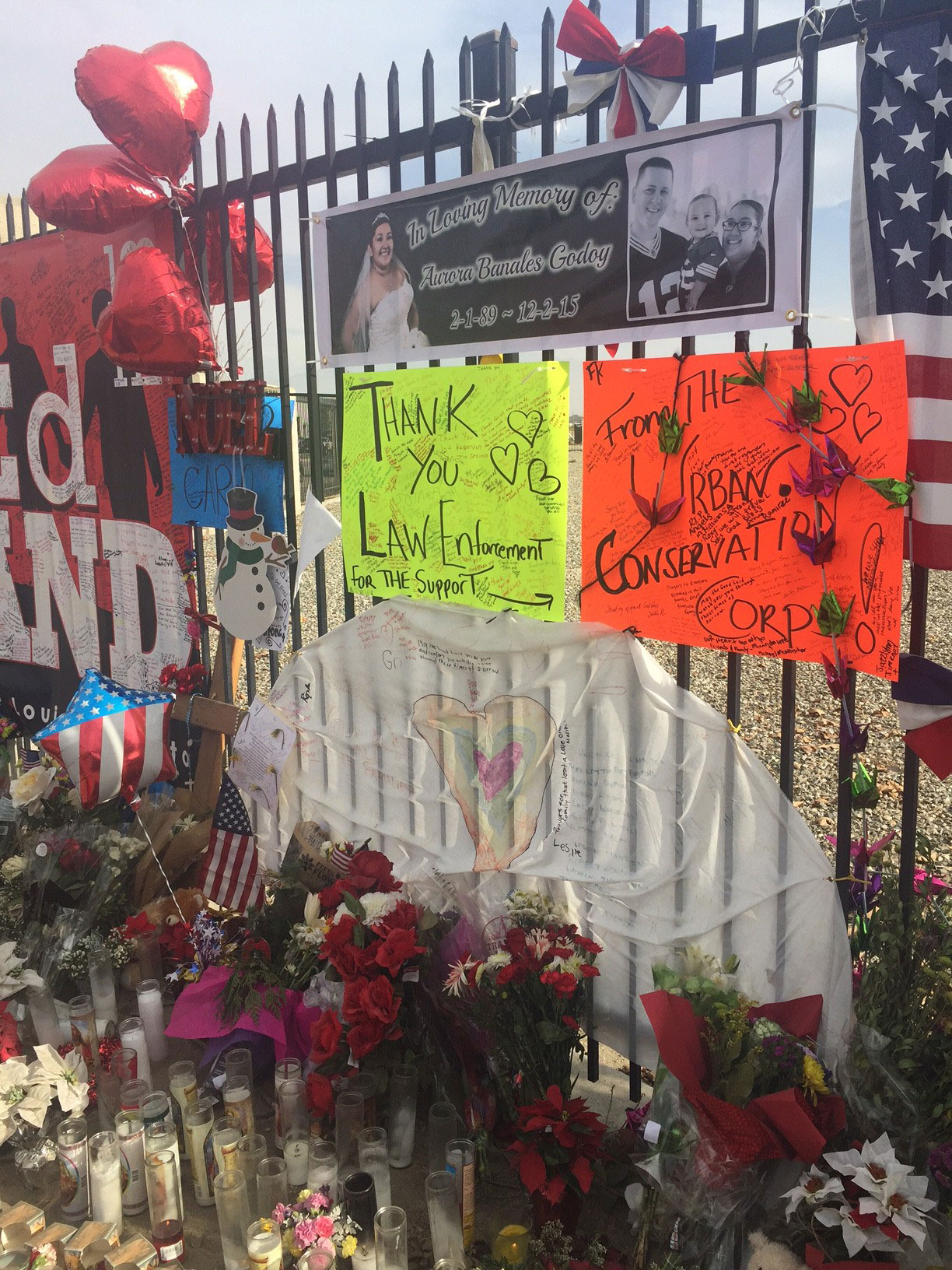 A makeshift memorial site showing photos of the victims, balloons and flowers